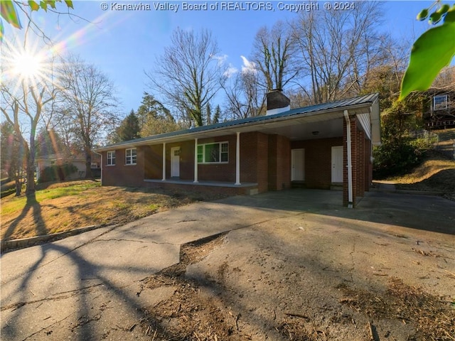 ranch-style home with a porch and a carport