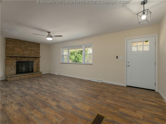 unfurnished living room featuring ceiling fan, a fireplace, and dark hardwood / wood-style floors