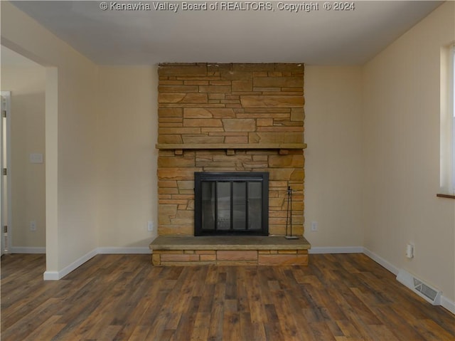 unfurnished living room with dark wood-type flooring and a fireplace