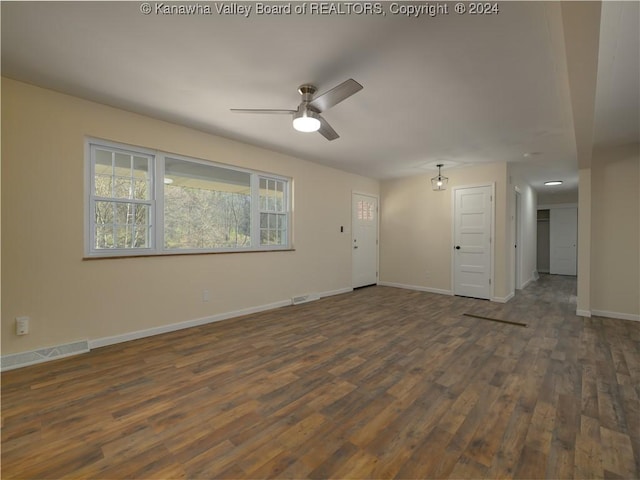 unfurnished living room featuring ceiling fan and dark wood-type flooring