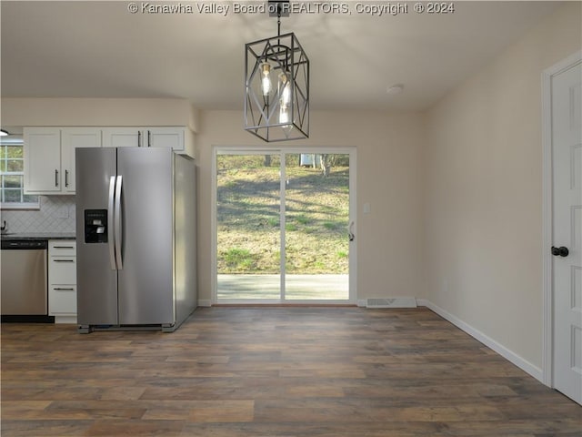 kitchen with tasteful backsplash, hanging light fixtures, appliances with stainless steel finishes, dark wood-type flooring, and white cabinets