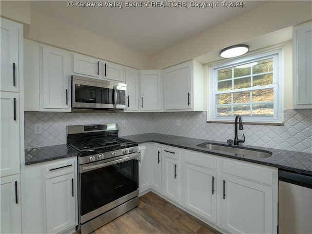 kitchen with appliances with stainless steel finishes, white cabinetry, and sink