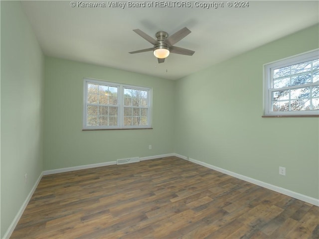 unfurnished room with ceiling fan, a healthy amount of sunlight, and dark hardwood / wood-style floors