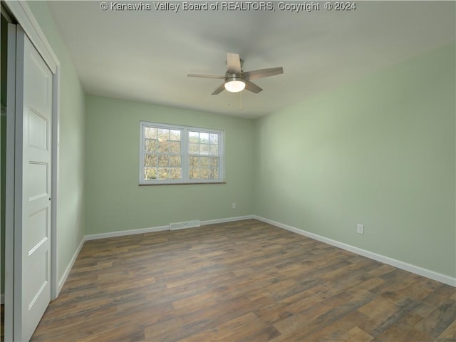 unfurnished bedroom featuring ceiling fan, dark wood-type flooring, and a closet