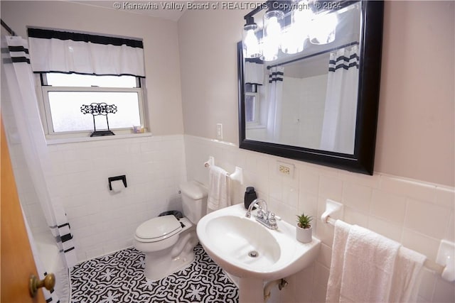 bathroom featuring sink, tile patterned flooring, tile walls, and toilet