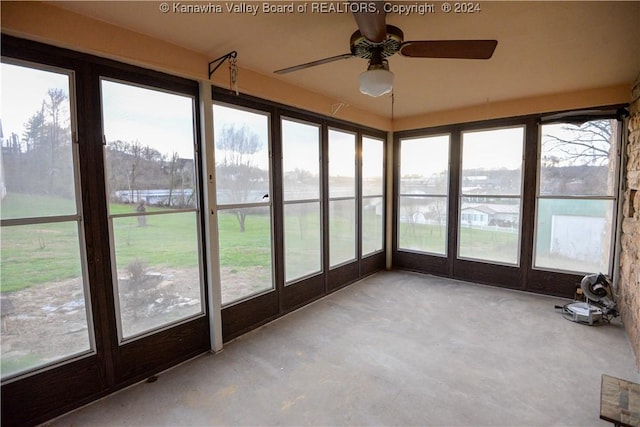 unfurnished sunroom with ceiling fan