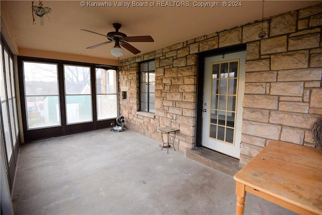 unfurnished sunroom featuring ceiling fan