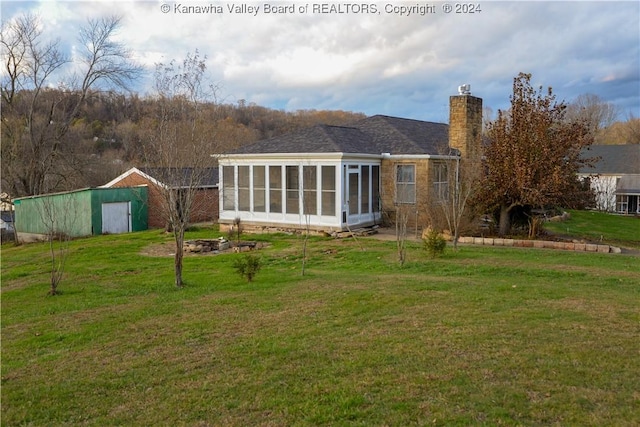 rear view of house with a sunroom and a yard