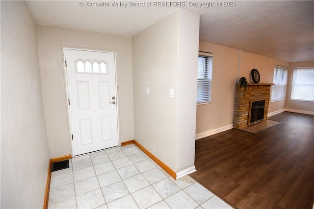 foyer with a fireplace and light wood-type flooring