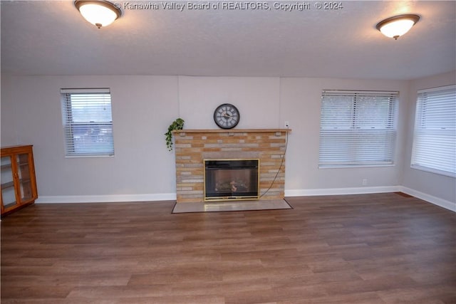 unfurnished living room featuring a fireplace and dark hardwood / wood-style floors