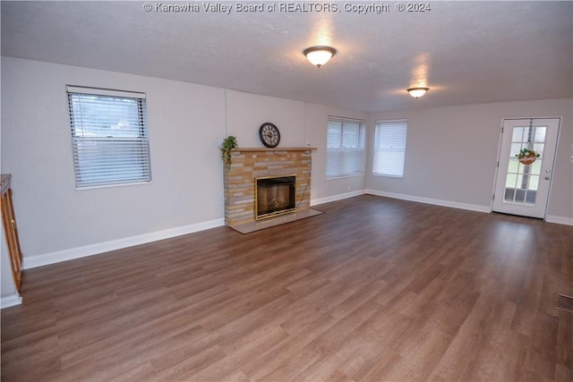 unfurnished living room featuring a textured ceiling, dark hardwood / wood-style flooring, and a fireplace