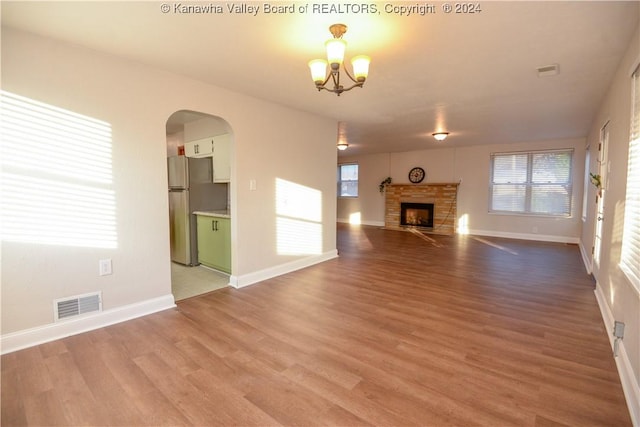 unfurnished living room featuring hardwood / wood-style flooring and a notable chandelier