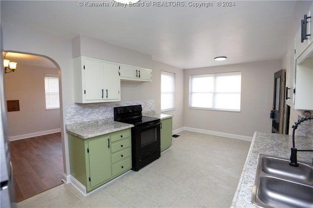 kitchen with backsplash, sink, green cabinetry, white cabinets, and black range with electric stovetop