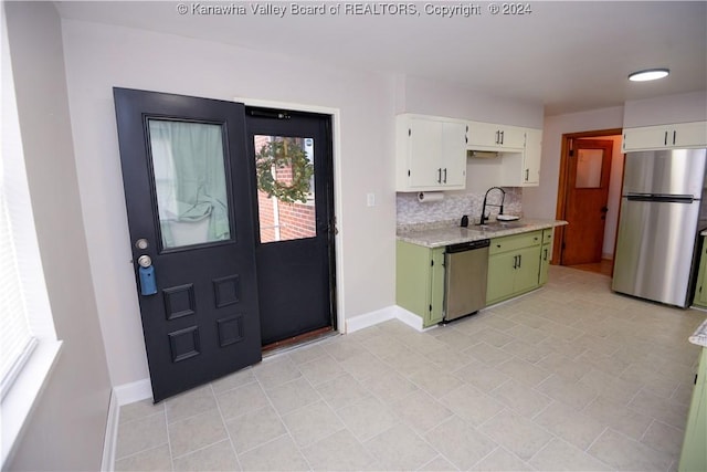 kitchen with appliances with stainless steel finishes, tasteful backsplash, sink, green cabinetry, and white cabinets