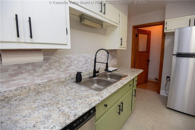 kitchen with appliances with stainless steel finishes, backsplash, sink, white cabinets, and green cabinets