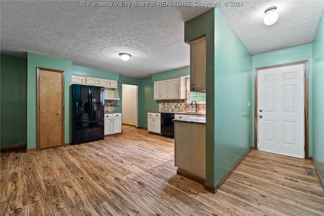 kitchen featuring light hardwood / wood-style flooring, white cabinetry, and black appliances