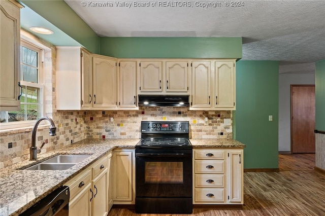 kitchen with black electric range oven, sink, dishwashing machine, light stone counters, and wood-type flooring