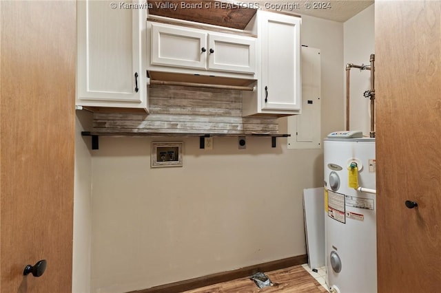 washroom featuring cabinets, electric water heater, electric panel, hookup for a washing machine, and light hardwood / wood-style flooring