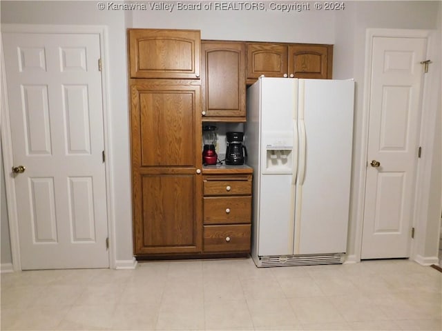 kitchen featuring white refrigerator with ice dispenser