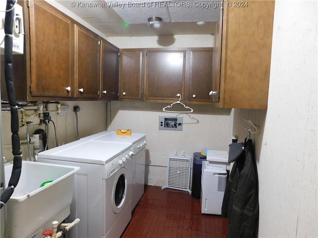 clothes washing area featuring cabinets, washing machine and clothes dryer, and sink