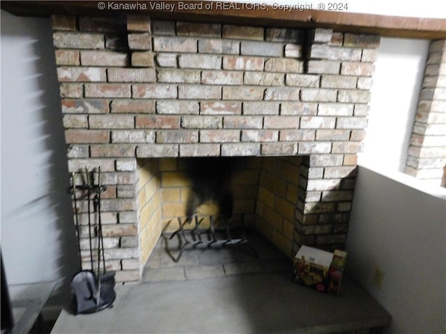 interior details with concrete flooring and a brick fireplace