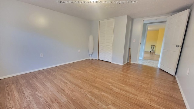 unfurnished bedroom with a closet and light wood-type flooring