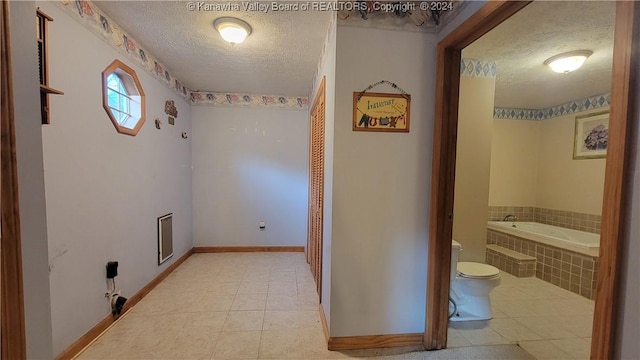 interior space featuring light tile patterned floors and a textured ceiling