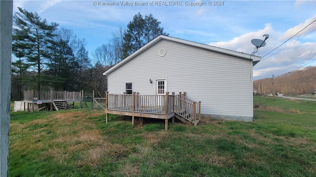 rear view of house with a yard and a deck