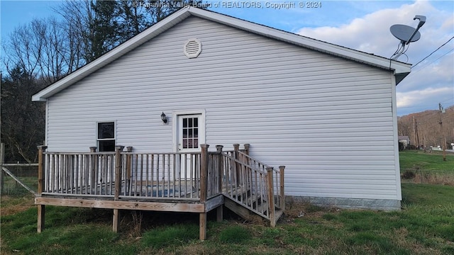 back of house with a lawn and a wooden deck