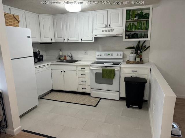 kitchen with light tile patterned floors, white appliances, white cabinetry, and sink