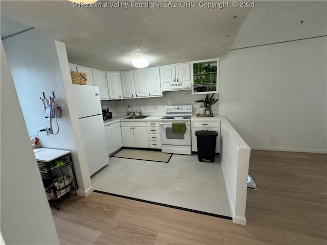 kitchen with white cabinets, light hardwood / wood-style floors, white appliances, and sink