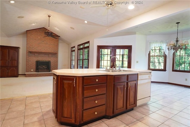 kitchen featuring dishwasher, sink, an island with sink, decorative light fixtures, and vaulted ceiling