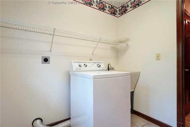 clothes washing area with washer / dryer, light tile patterned floors, and sink