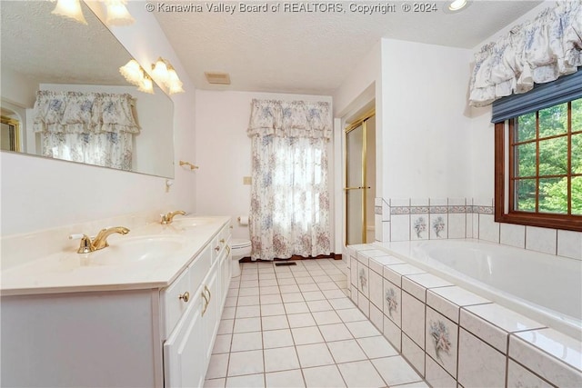 bathroom with vanity, a textured ceiling, and tiled tub