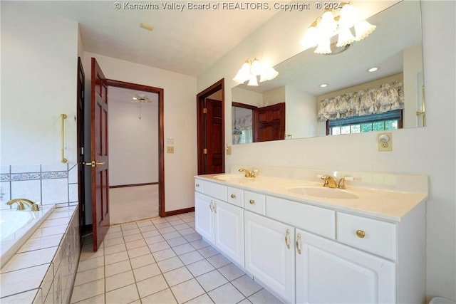 bathroom with tile patterned floors, tiled bath, and vanity