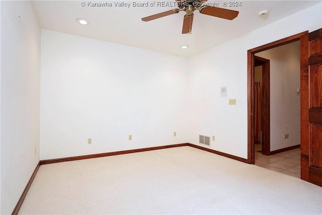 spare room with ceiling fan and light carpet