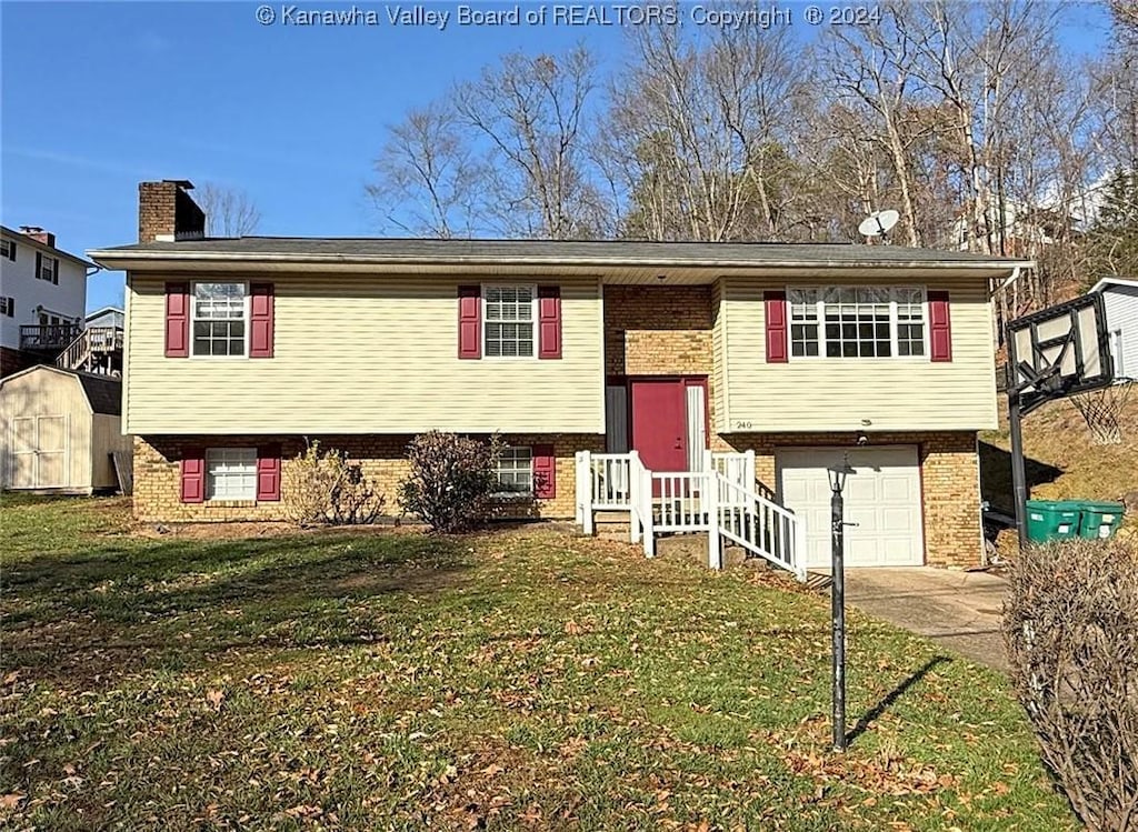 raised ranch with a front lawn and a garage