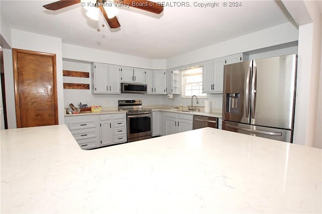 kitchen with stainless steel appliances, gray cabinets, ceiling fan, and sink