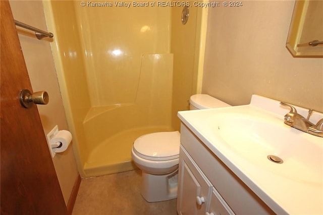 bathroom with toilet, vanity, and walk in shower