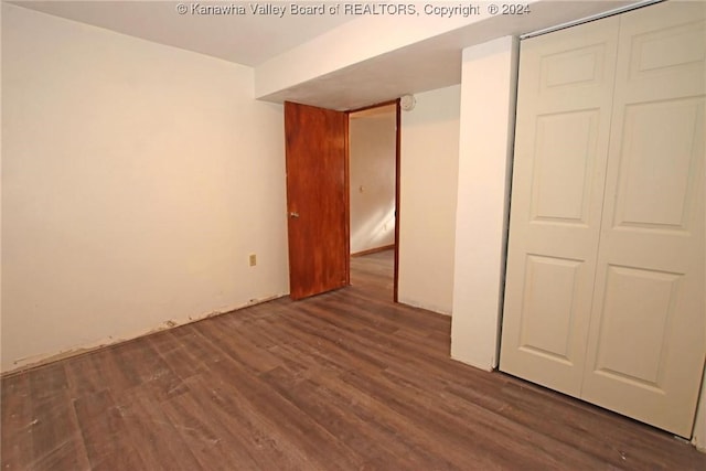 unfurnished bedroom featuring dark wood-type flooring and a closet