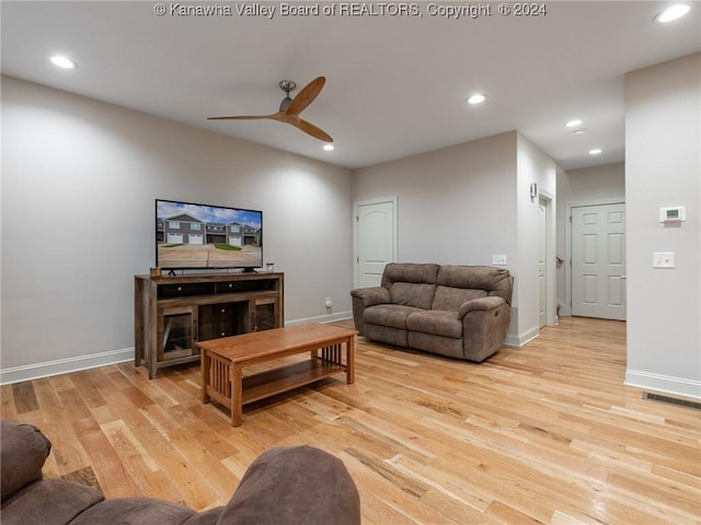 living room with light wood-type flooring and ceiling fan