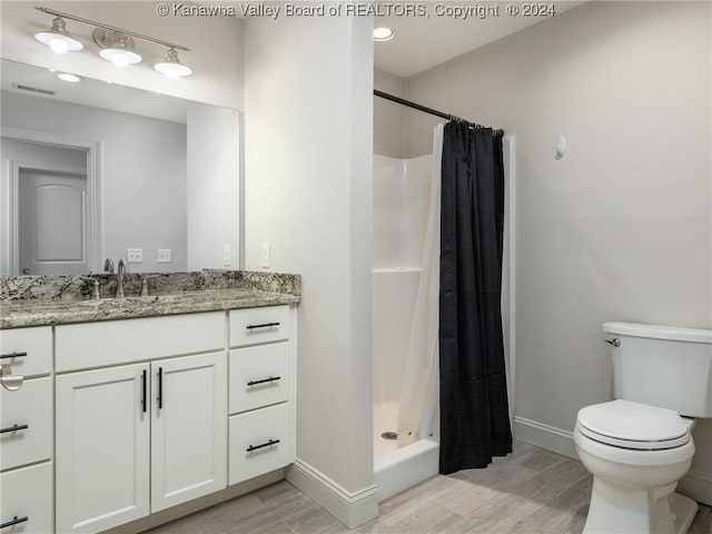 bathroom featuring vanity, curtained shower, toilet, and wood-type flooring