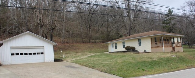 view of side of home featuring a lawn, a porch, a garage, and an outdoor structure