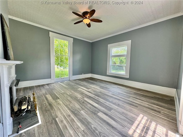 unfurnished living room with crown molding, ceiling fan, a healthy amount of sunlight, and hardwood / wood-style flooring