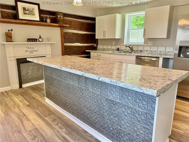 kitchen featuring white cabinets, light wood-type flooring, stainless steel appliances, and sink