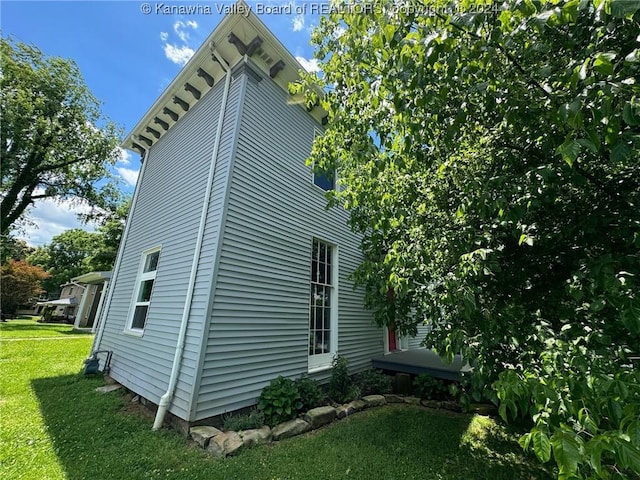 view of side of property with a lawn