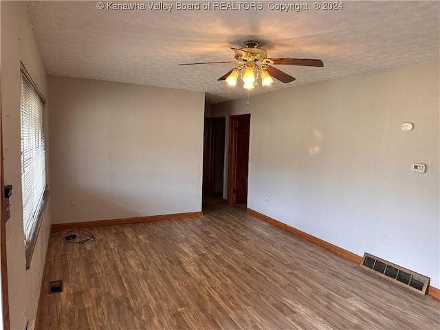 spare room featuring ceiling fan, hardwood / wood-style floors, and a textured ceiling