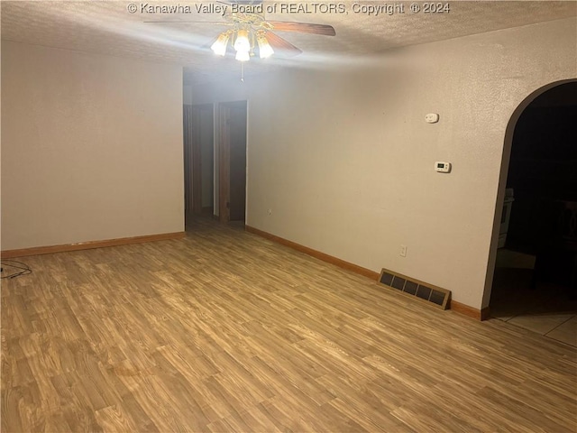 spare room featuring ceiling fan, a textured ceiling, and light hardwood / wood-style flooring