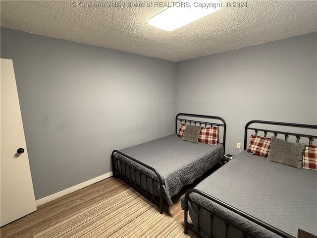 bedroom featuring hardwood / wood-style flooring and a textured ceiling