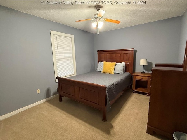 bedroom featuring light carpet, ceiling fan, and a textured ceiling